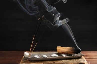 Aromatic incense sticks smoldering on wooden table