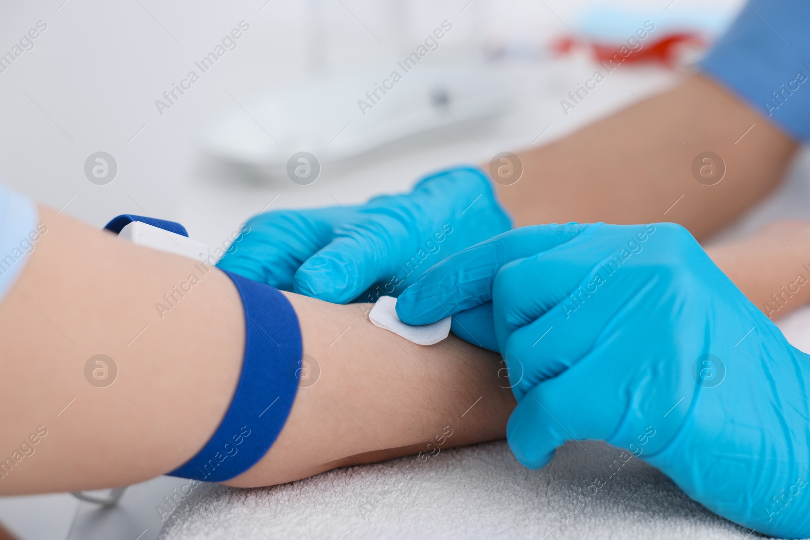 Photo of Nurse inserting IV into arm of patient in hospital, closeup