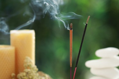 Photo of Two incense sticks smoldering against blurred background