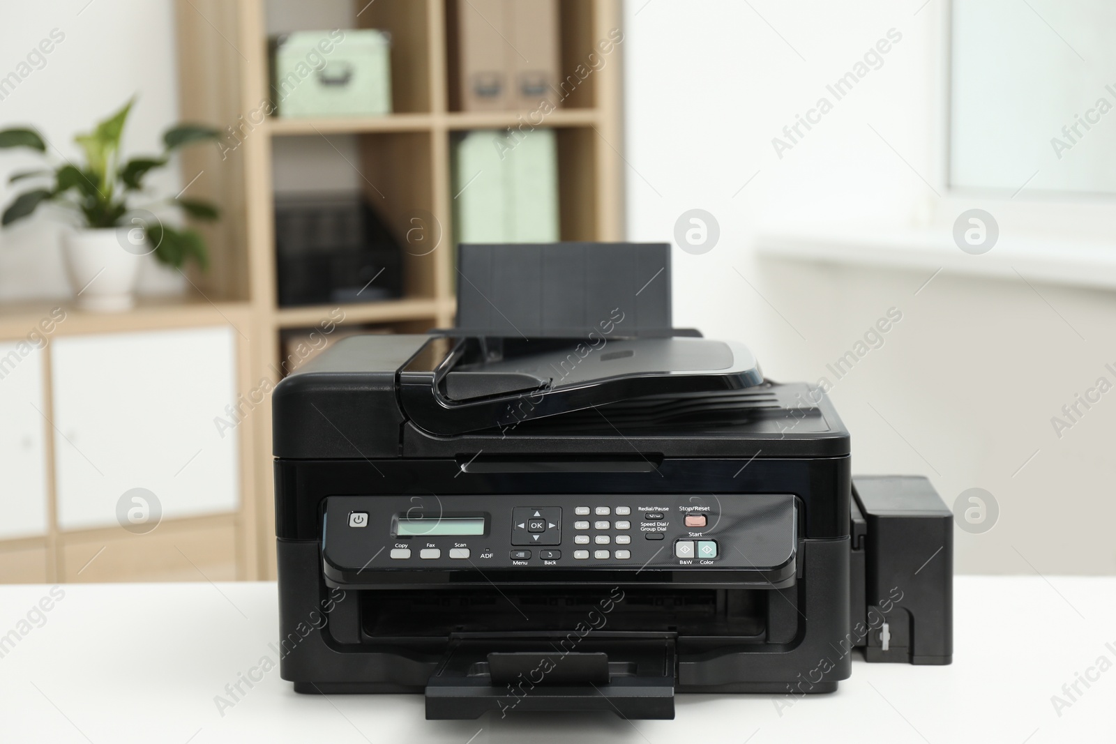 Photo of Modern printer on white table in office