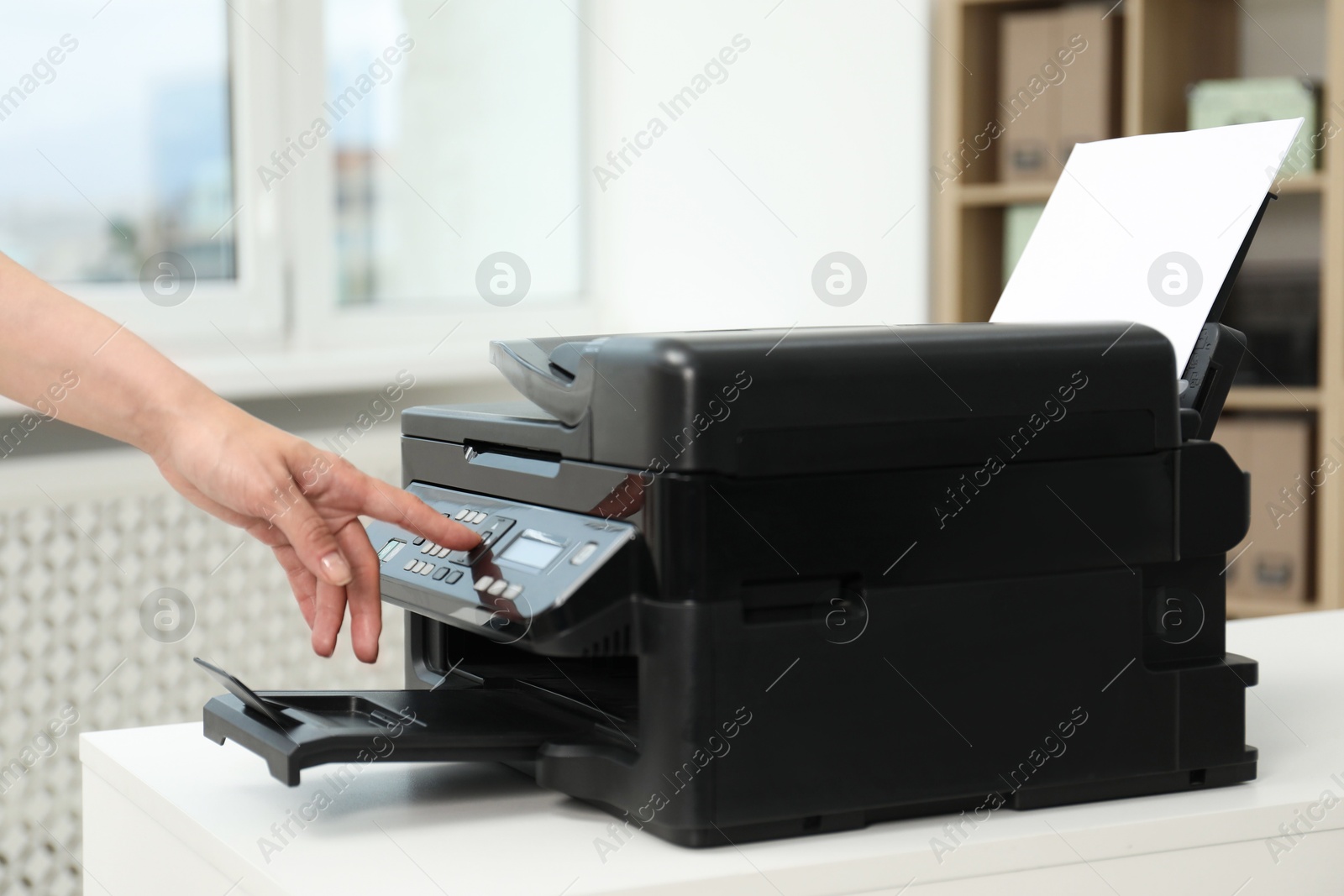 Photo of Woman using modern printer at workplace indoors, closeup