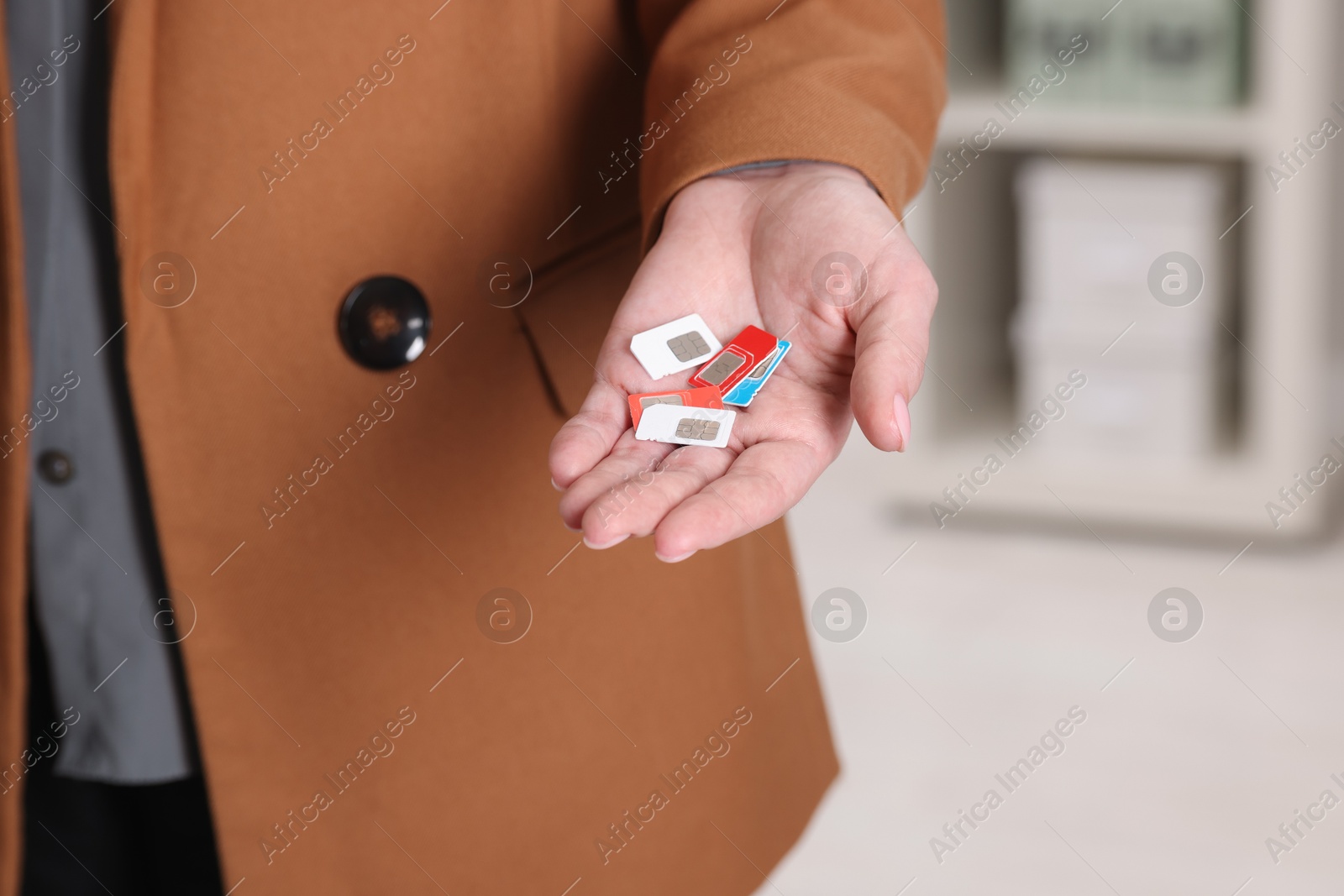 Photo of Woman holding SIM cards indoors, closeup view