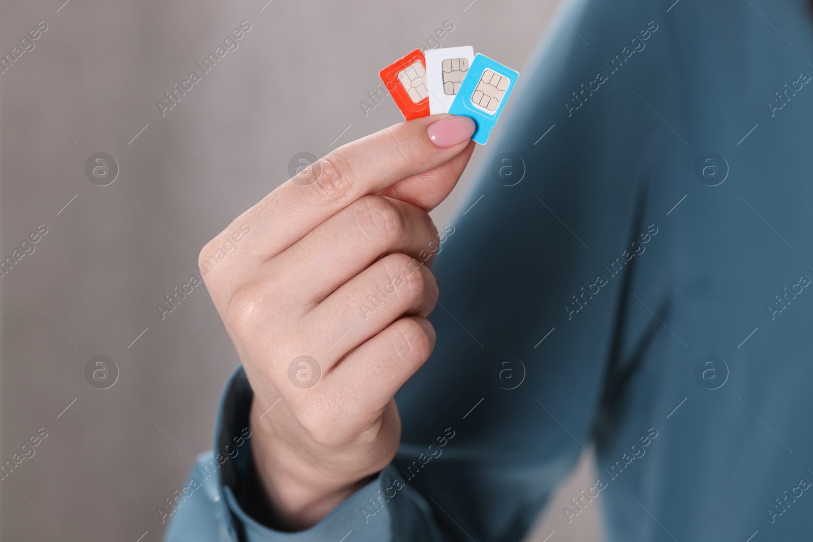 Photo of Woman holding SIM cards indoors, closeup view