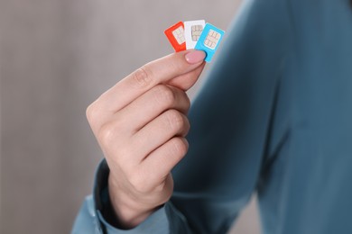 Photo of Woman holding SIM cards indoors, closeup view