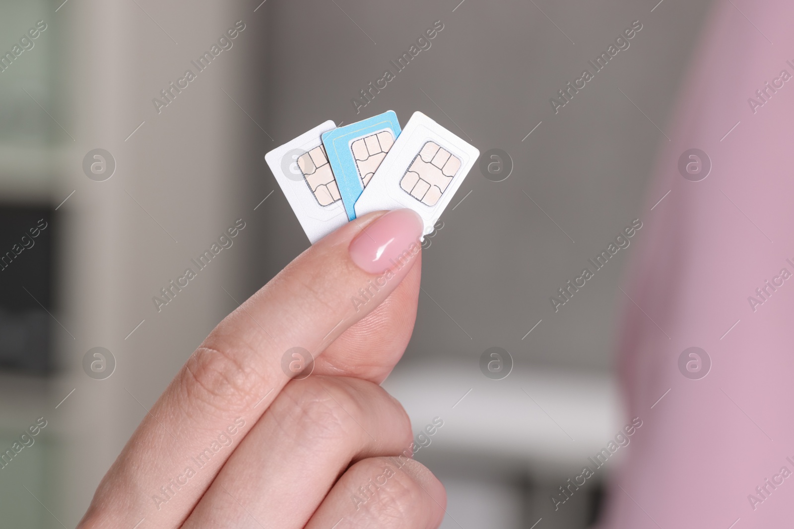 Photo of Woman holding SIM cards indoors, closeup view