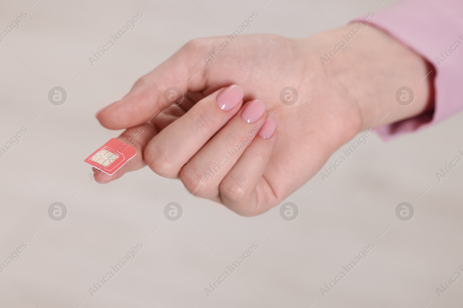 Photo of Woman holding SIM card indoors, closeup view