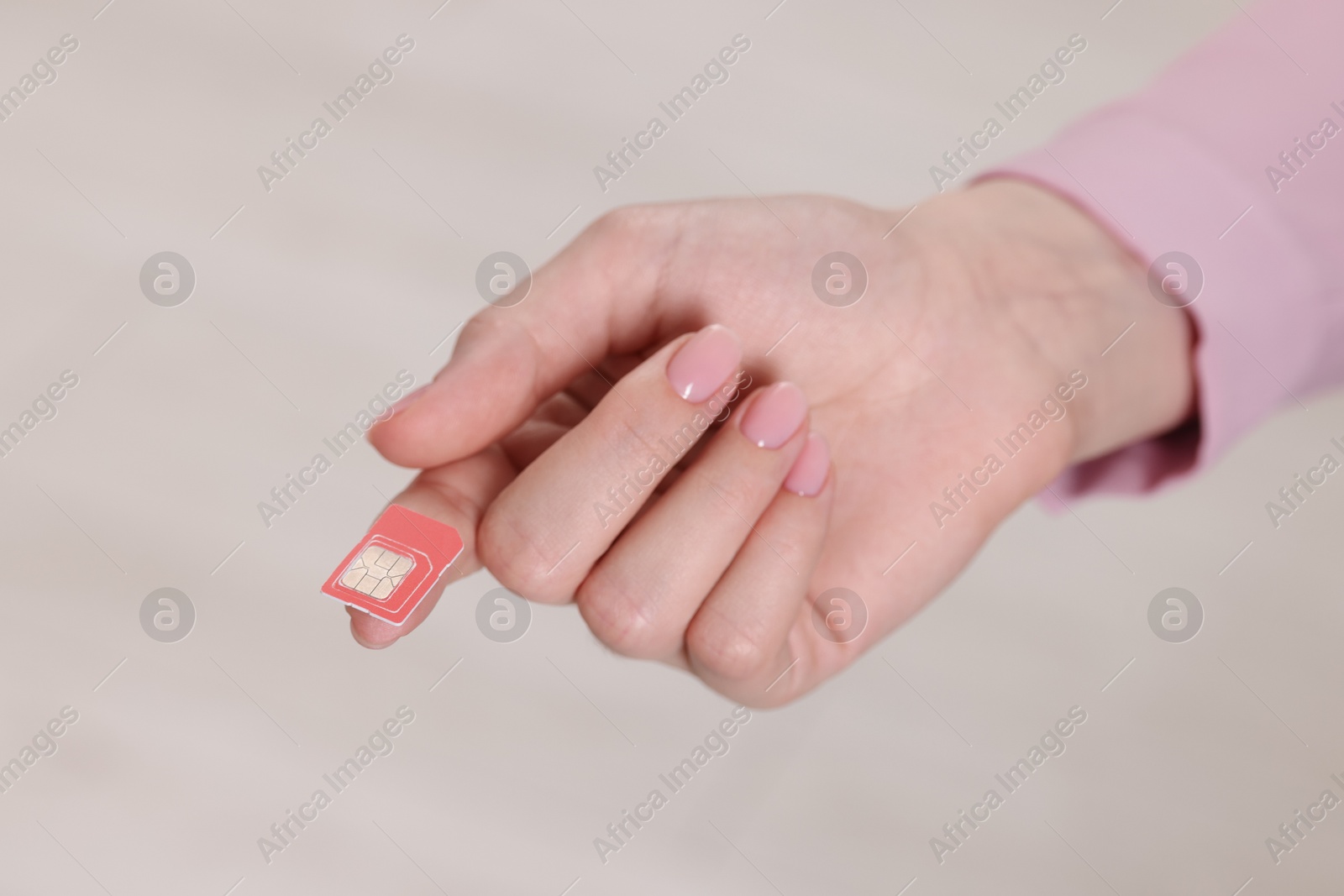 Photo of Woman holding SIM card indoors, closeup view