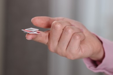 Photo of Woman holding SIM cards indoors, closeup view