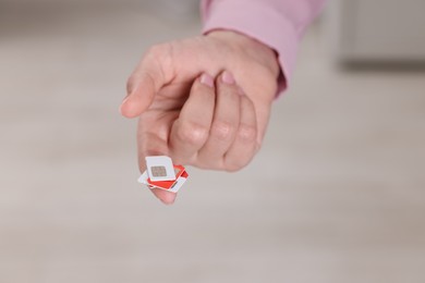 Photo of Woman holding SIM cards indoors, closeup view