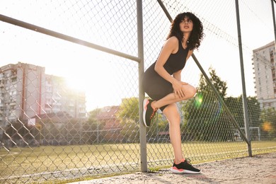 Sportswoman with leg injury suffering from knee pain at stadium, low angle view