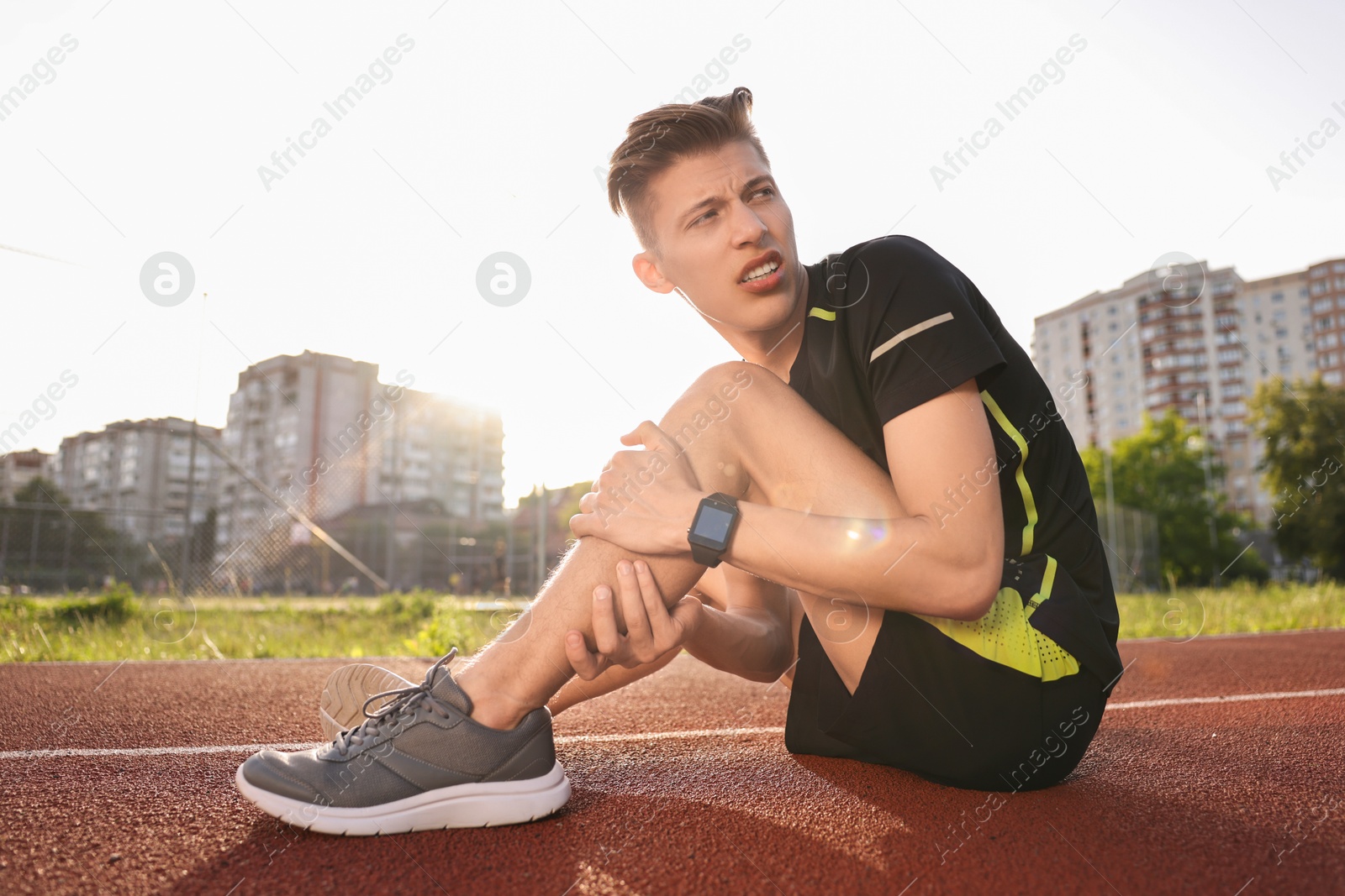 Photo of Sportsman with injured leg at stadium on sunny day