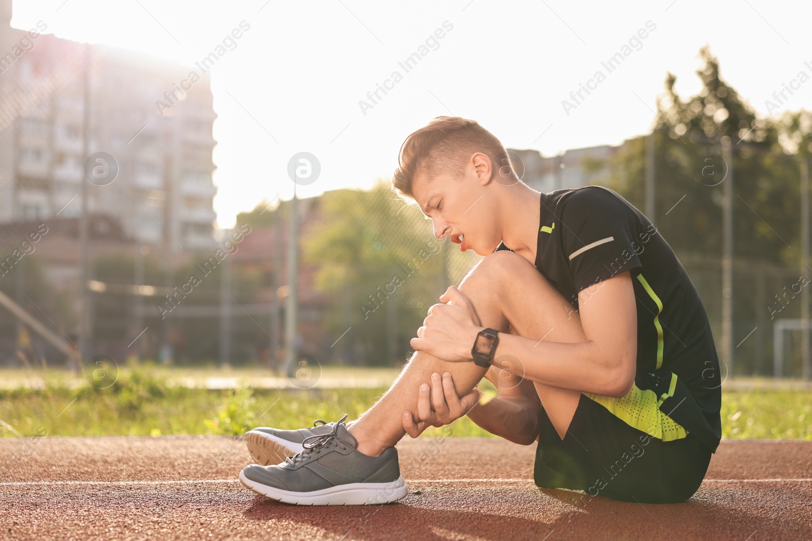 Photo of Sportsman with leg injury at stadium, space for text