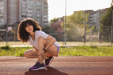 Photo of Sportswoman with leg injury at stadium, space for text