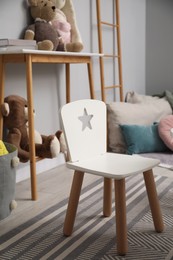 Photo of Small chair, console table and toys in child room. Interior design