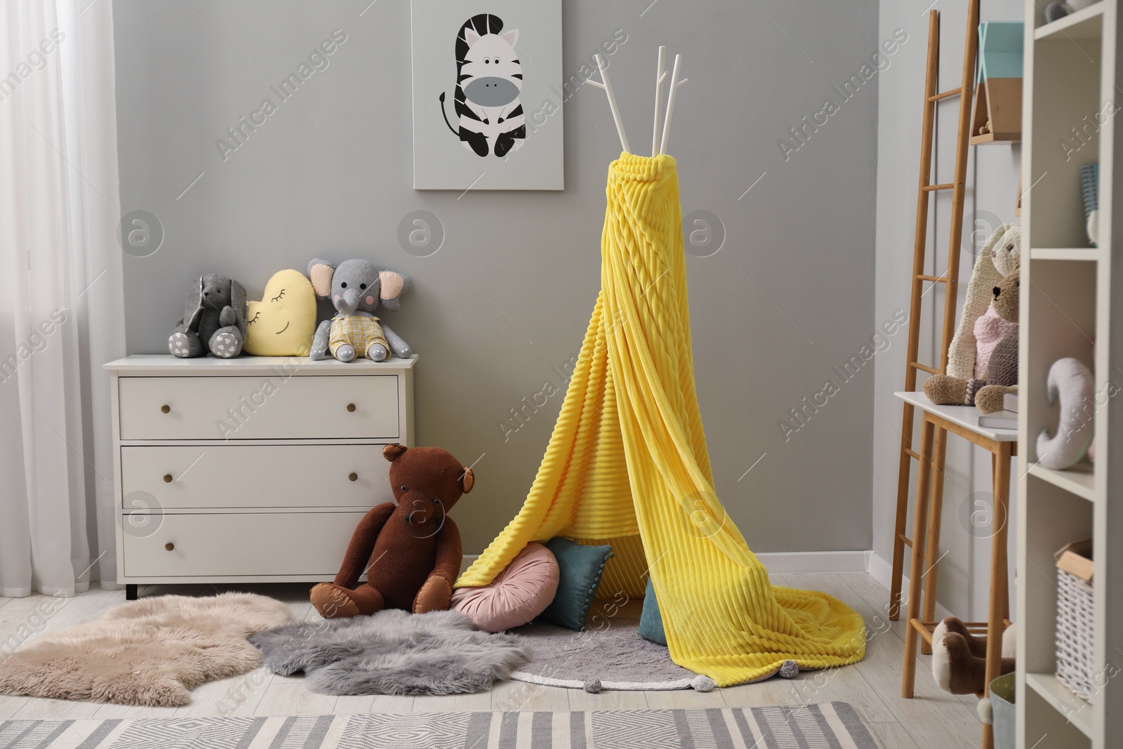 Photo of Stylish child room interior with modern furniture, toys and play tent