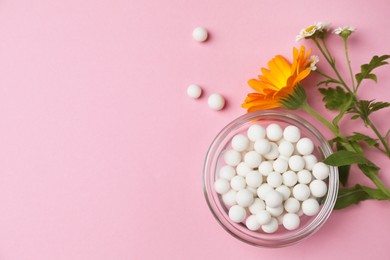 Photo of Homeopathic remedy. Pills in glass bowl, calendula and chamomile flowers on pink background, flat lay. Space for text