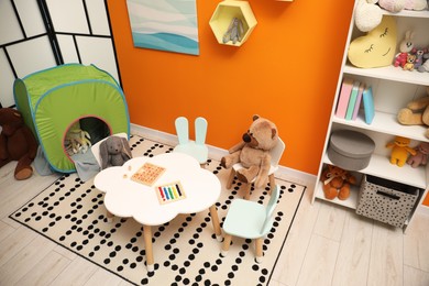 Photo of Stylish child room interior with different toys and furniture