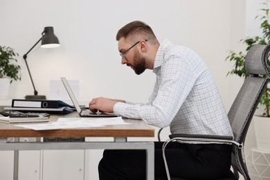 Photo of Man with poor posture working in office