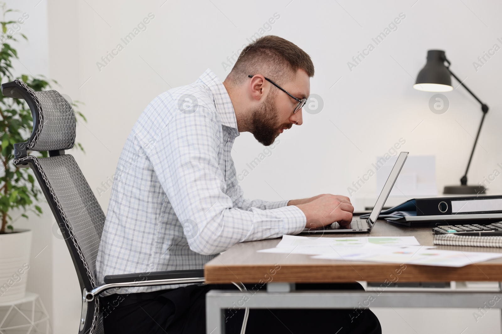 Photo of Man with poor posture working in office