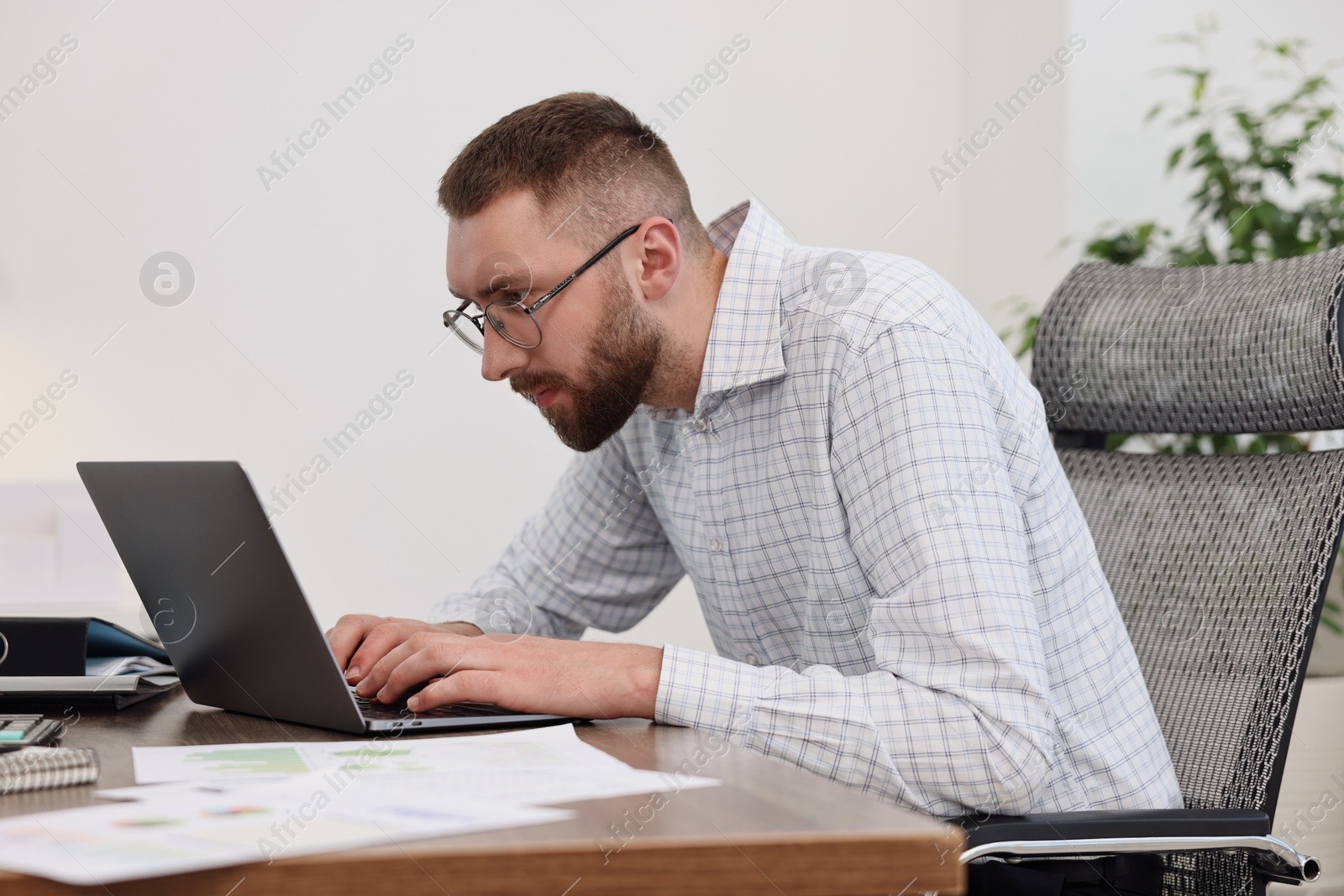 Photo of Man with poor posture working in office