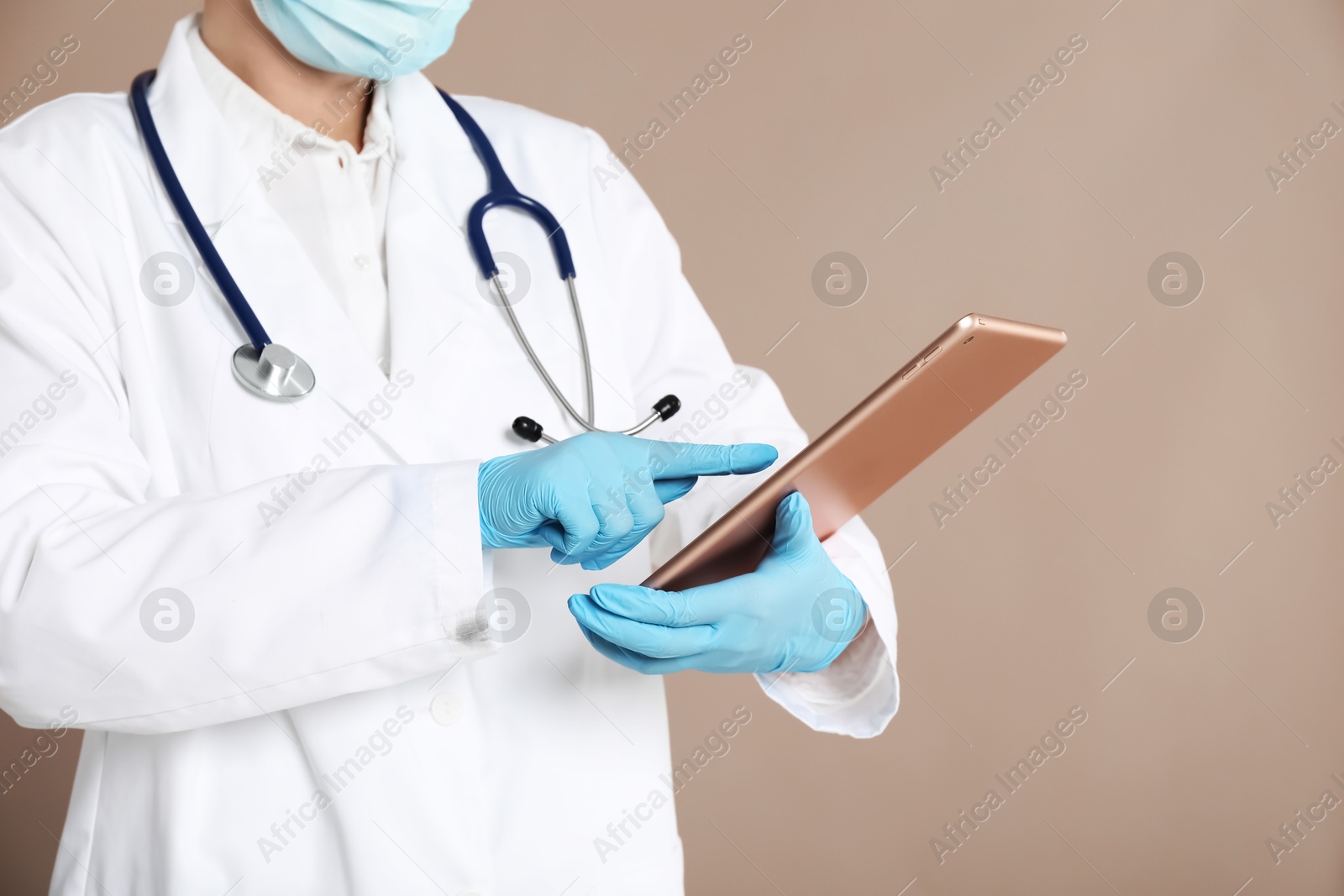 Photo of Doctor with tablet on beige background, closeup view