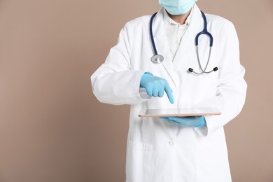 Photo of Doctor with tablet on beige background, closeup view. Space for text