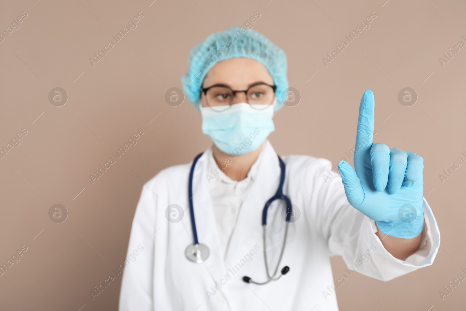 Photo of Doctor pointing at something on beige background, selective focus