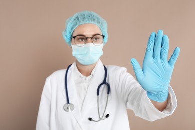 Doctor touching something on beige background, selective focus