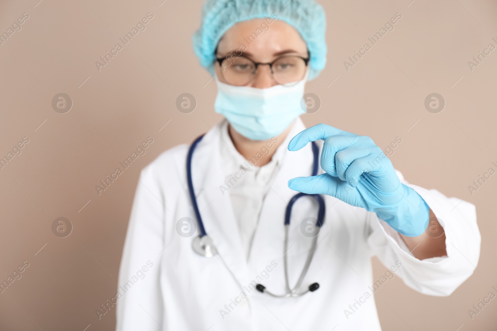 Photo of Doctor holding something on beige background, selective focus