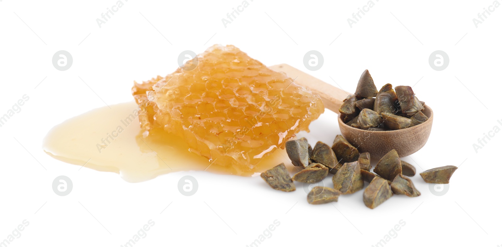 Photo of Natural honeycomb and spoon with propolis granules isolated on white