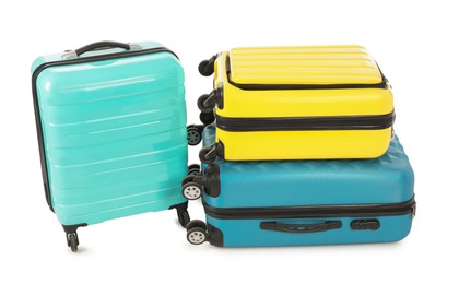 Photo of New yellow and light blue suitcases isolated on white