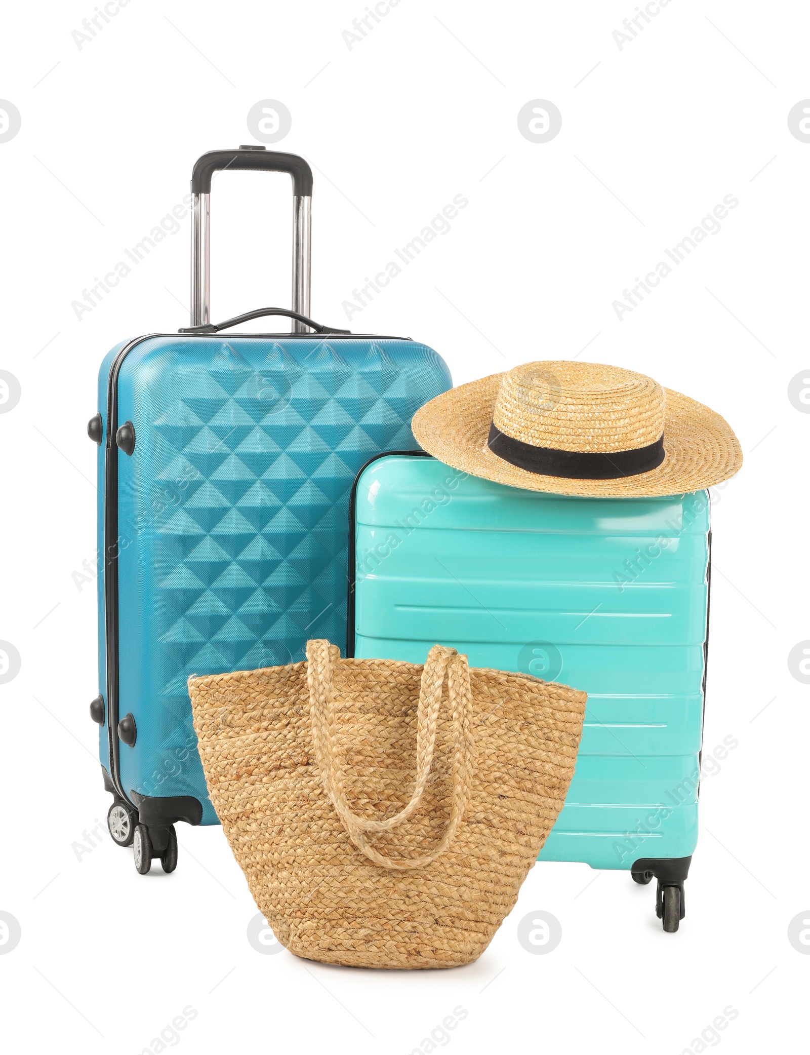 Photo of Light blue suitcases, bag and straw hat isolated on white