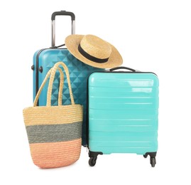 Photo of Light blue suitcases, bag and straw hat isolated on white