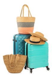 Light blue suitcases, bags and straw hats isolated on white