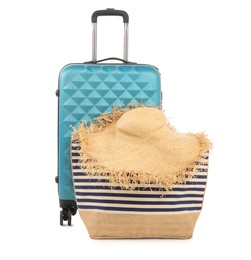 Photo of Light blue suitcase, bag and straw hat isolated on white