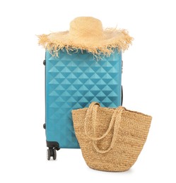 Photo of Light blue suitcase, bag and straw hat isolated on white