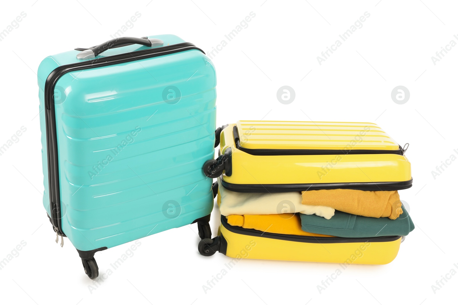 Photo of New suitcases with clothes isolated on white