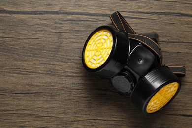 Photo of One respirator mask on wooden background, top view. Space for text