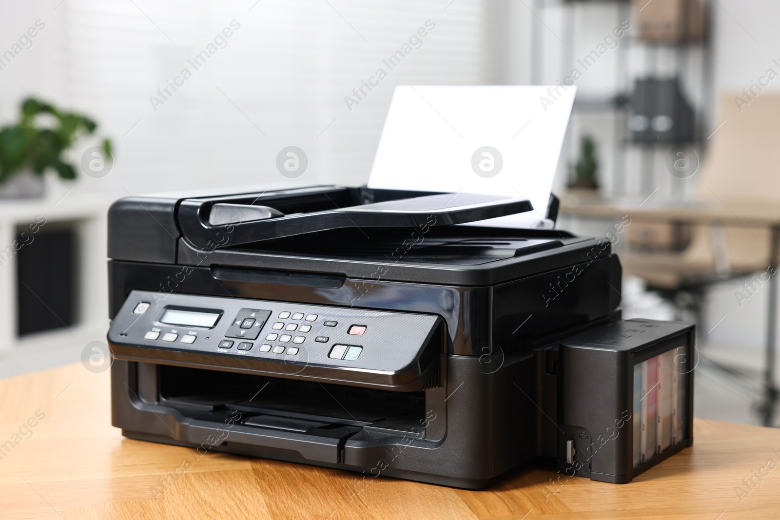 Photo of Modern printer with paper on table in office