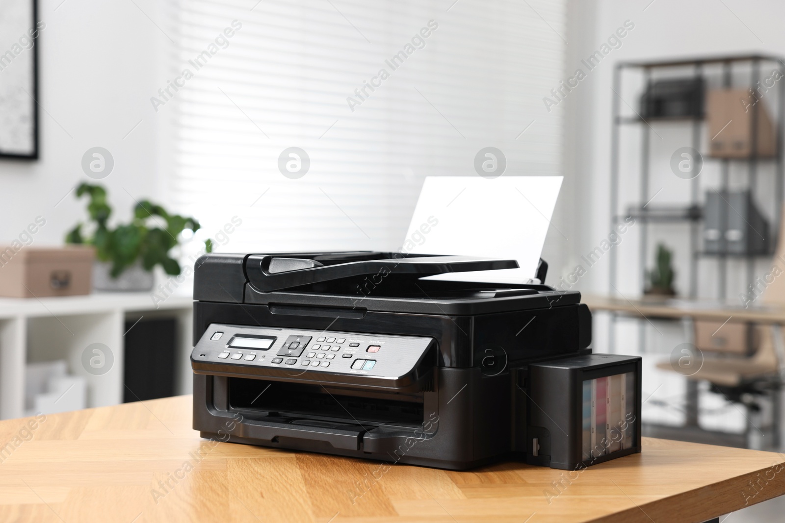 Photo of Modern printer with paper on table in office