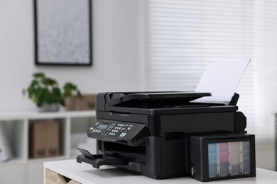 Photo of Modern printer with paper on table in office. Space for text