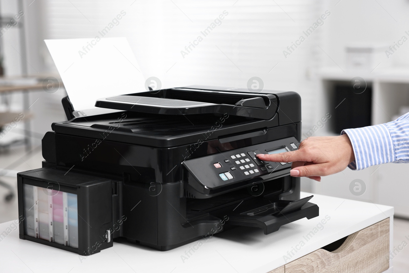 Photo of Woman using modern printer at workplace indoors, closeup