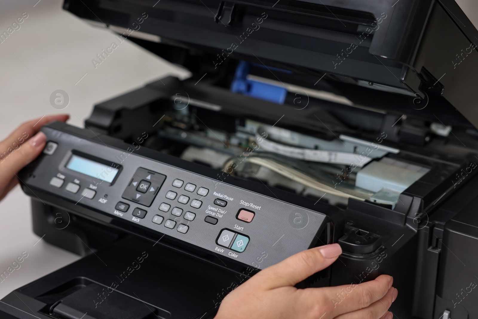 Photo of Woman using modern printer at workplace indoors, closeup