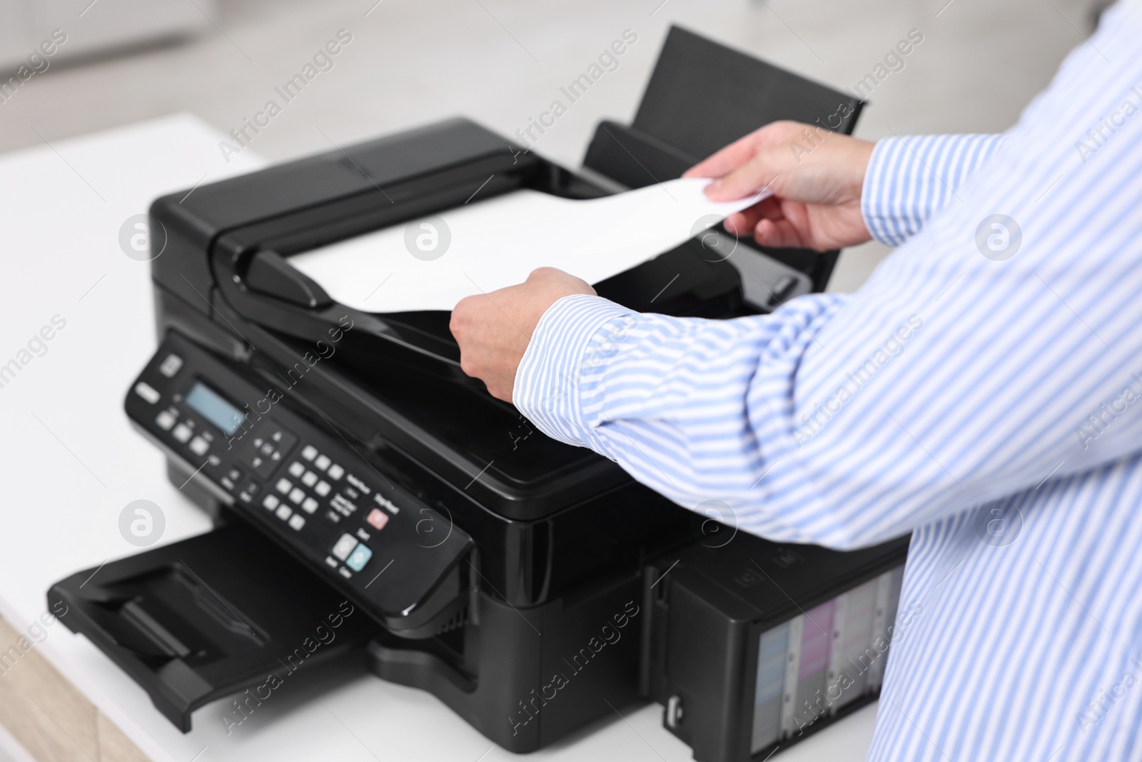 Photo of Woman using modern printer at workplace indoors, closeup