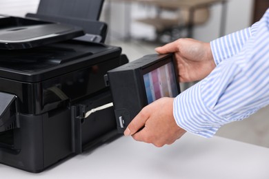 Photo of Woman using modern printer at workplace indoors, closeup