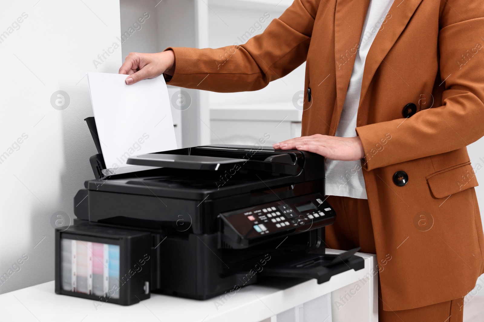 Photo of Woman using modern printer at workplace indoors, closeup