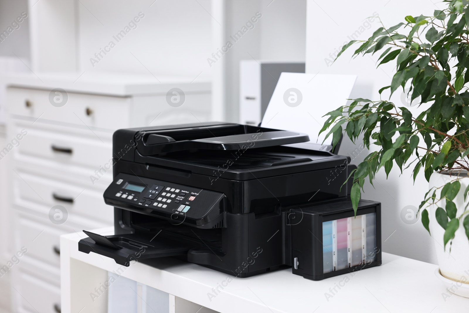 Photo of Modern printer with paper on table in office