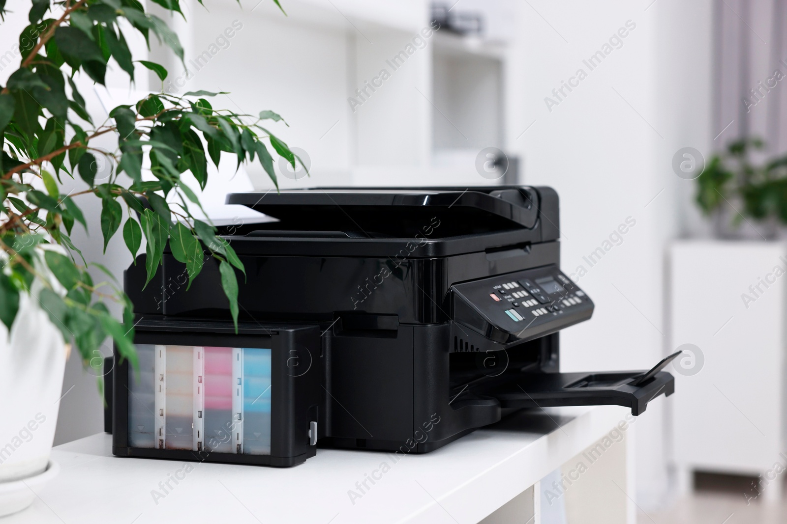 Photo of Modern printer with paper on table in office