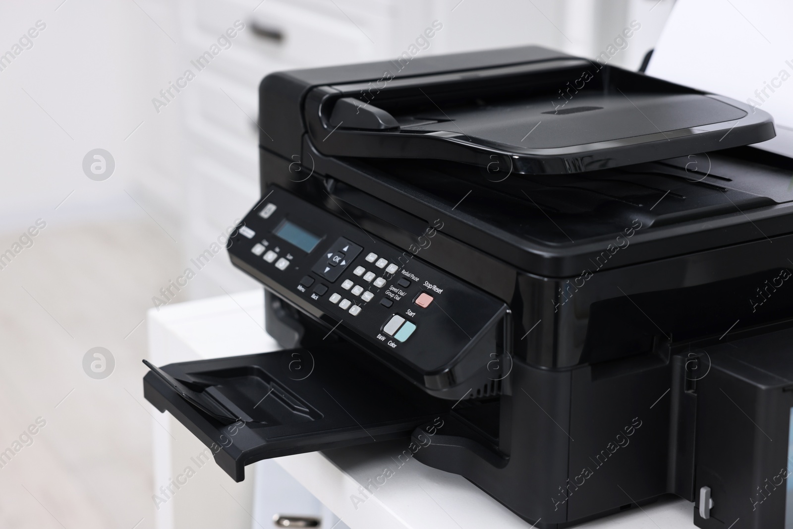 Photo of Modern printer with paper on table in office, closeup