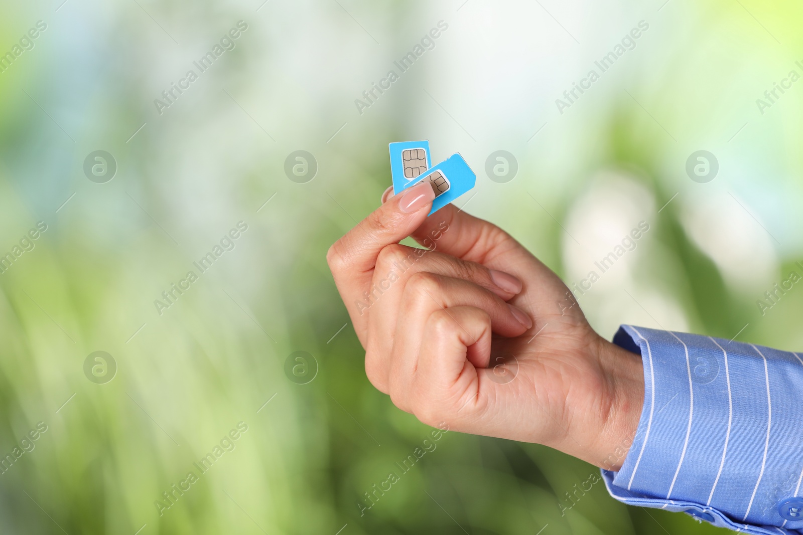 Photo of Woman with SIM card against blurred green background, closeup, Space for text